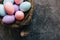 Happy Easter concept. Preparation for holiday. Colorful pastel decorated easter eggs in nest on grunge scratched dark