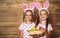 Happy easter! cute twins girls sisters dressed as rabbits with e