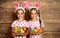 Happy easter! cute twins girls sisters dressed as rabbits with e