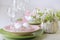 Happy easter. Decor and table setting of the Easter table is a vase with pink tulips and dishes of pink and green color