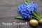 Happy Easter.Easter decoration with Blue Scilla Squill flowers,golden Easter egg on old wooden background.