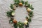 Happy Easter! Easter eggs and spring flowers in wreath on rustic linen, flat lay. Aesthetic holiday