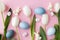 Happy Easter! Easter eggs, tulips, bunnies flat lay on pink background. Modern natural dyed blue easter eggs and white tulips