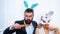 Happy easter and funny easter day. Surprised bunny couple wearing bunny ears and eat carrot. Smile easter.