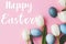 Happy Easter greeting card. Happy Easter text and modern Easter eggs, tulips and bunnies flat lay on pink background. Seasons
