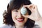 Happy Easter greetings. Beautiful young woman in bunny ears smiling and holding easter egg near face on white background indoors,