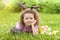 Happy Easter kid. little girl with very peri ears, small rabbit, grey bunny hunting for colorful eggs on green grass