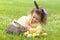 Happy Easter kid. little girl with very peri ears, small rabbit, grey bunny hunting for colorful eggs on green grass. spring holid