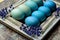 Happy Easter rustic background. DIY dyed various shades of blue Easter eggs and vintage wooden picture frame.