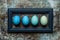 Happy Easter rustic background. DIY dyed various shades of blue Easter eggs and wooden picture frame.