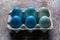 Happy Easter rustic concept. DIY dyed various shades of blue Easter eggs on retro rusty metal background.