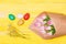 Happy easter season. Collecting easter eggs. Colorful eggs and bouquet fresh tulip flowers on yellow background top view