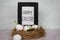 Happy Easter sign in black frame sitting in bird nest with eggs