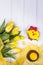 Happy Easter. Spring flowers yellow daffodils and tulips, easter eggs, candle and gingerbread chicken on a white background. Top v