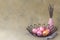 Happy easter. Spring holiday concept. Painted pink eggs in a metal basket on a light background. A bouquet of lavender in a vase.