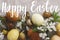 Happy Easter text on modern colorful easter eggs with spring flowers flat lay on rustic linen cloth, handwritten sign. Beautiful
