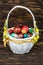 Happy Easter. Traditionally, colorfully painted eggs in a basket. Background of old boards, festive decor