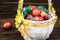 Happy Easter. Traditionally, colorfully painted eggs in a basket. Background of old boards, festive decor