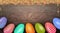 Happy Easter wooden background with colorful painted eggs and sugar balls powder. Top view with copy space.