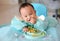 Happy eating Asian baby boy, 7 months old eating with Baby Led Weaning BLW method, Self-Feeding