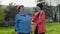 Happy elder grandmother and granddaughter talking together. Real time. Grass on the background. International Day of