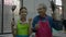 Happy elderly Asian grandfather and his young granddaughter in apron show funny ready gestures while raise a spatula and pan.