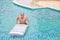 Happy elderly caucasian swimming and playing rubber boat in swimming pool during retirement holiday with relaxation and smiling