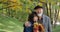 Happy elderly couple in hugs enjoys autumn in a cozy park among the trees - slow motion.