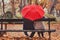 Happy elderly couple in love, retired people enjoying romantic moment under umbrella
