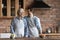 Happy elderly father and adult son cooking in kitchen