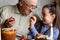 Happy elderly man granfather preparing for Easter with granddaughter. painted colored eggs for Easter