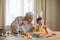 Happy elderly man granfather preparing for Easter with grandson. Portrait of smiling boy with bunny ears painted  colored eggs for