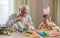 Happy elderly man granfather preparing for Easter with grandson. Portrait of smiling boy with bunny ears painted  colored eggs for