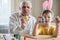 Happy elderly man granfather preparing for Easter with grandson. Portrait of smiling boy with bunny ears painted  colored eggs for