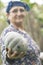 Happy elderly muslim woman farmer holding a single pumpkin