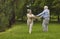 Happy elderly pensioners, man and woman, husband and wife, dancing together