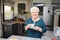 Happy elderly senior active woman drinking coffee in a modern kitchen at home