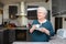 Happy elderly senior active woman drinking coffee in a modern kitchen at home