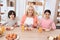 Happy elderly woman dines with her grandchildren at dinner table in kitchen.