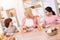 Happy elderly woman dines with her grandchildren at dinner table in kitchen.