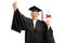 Happy elderly woman in a graduation gown holding a diploma and gesturing happiness with hand