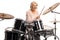 Happy elderly woman with headphones playing drums