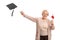 Happy elderly woman holding a degree and throwing a graduation hat