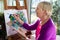 Happy elderly woman painting for fun at home