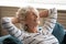 Happy elderly woman relax sleeping on cozy sofa