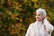 Happy elderly woman touchs her hair in nature