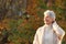 Happy elderly woman touchs her hair in nature