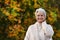 Happy elderly woman touchs her hair in nature