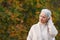 Happy elderly woman touchs her hair in nature