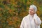 Happy elderly woman touchs her hair in nature